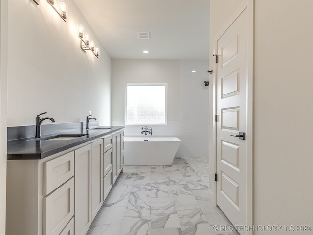 bathroom featuring double vanity, visible vents, a soaking tub, marble finish floor, and a sink