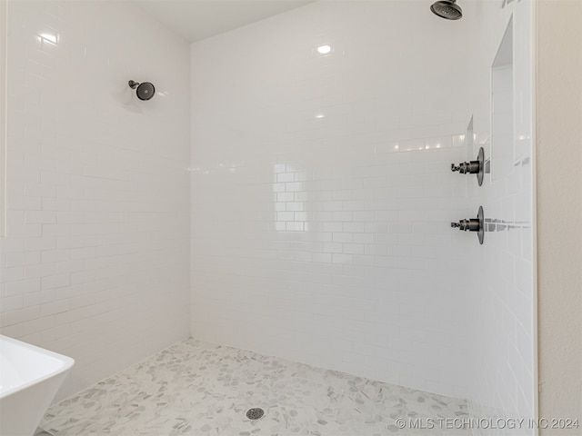 full bathroom featuring a tile shower and a freestanding bath