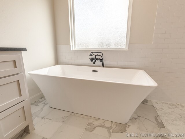 bathroom with a tub to relax in and vanity