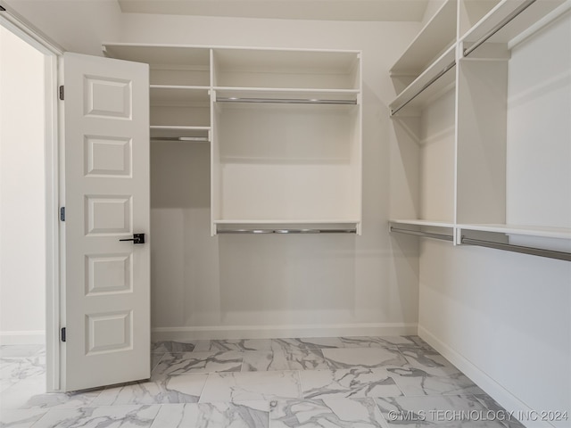 spacious closet featuring marble finish floor