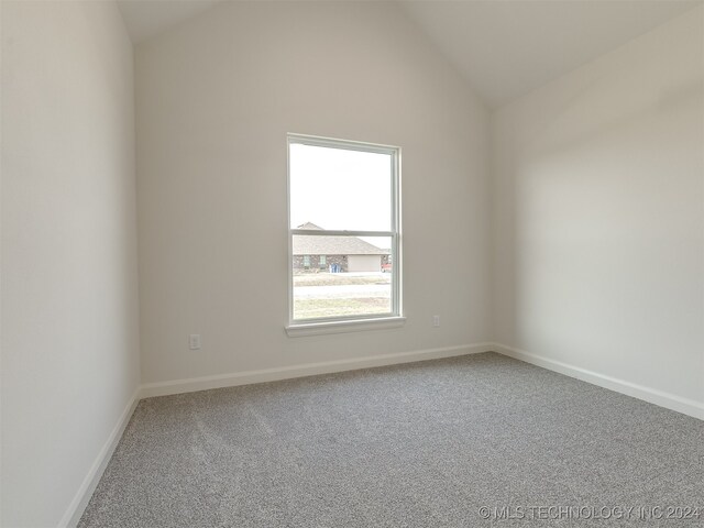 empty room featuring carpet and lofted ceiling