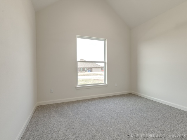 carpeted empty room with lofted ceiling and baseboards