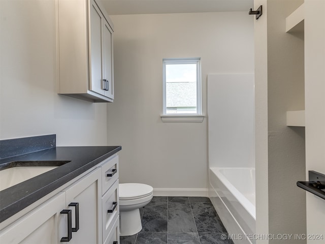 bathroom featuring toilet, vanity, baseboards, a bath, and walk in shower