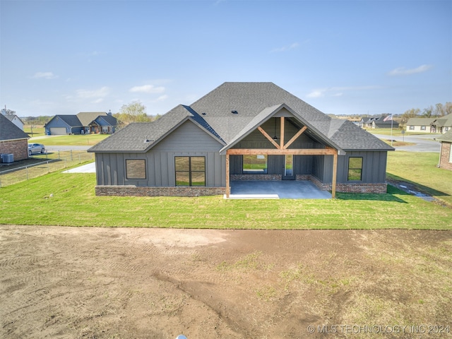 view of front of home with a residential view, roof with shingles, a patio area, a front lawn, and board and batten siding