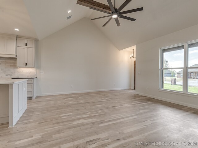 unfurnished living room with ceiling fan, high vaulted ceiling, and light hardwood / wood-style flooring