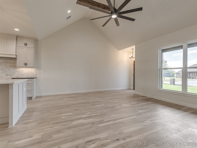 unfurnished living room with visible vents, baseboards, a ceiling fan, light wood-style flooring, and high vaulted ceiling