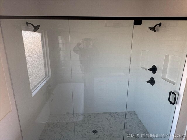 bathroom with a shower with shower door and tile patterned floors