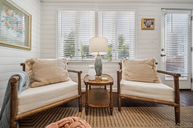 living area featuring hardwood / wood-style floors and wood walls