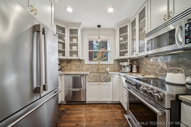 kitchen featuring high end appliances, decorative backsplash, sink, dark hardwood / wood-style floors, and decorative light fixtures