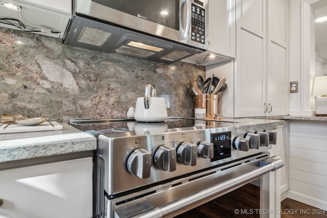 room details with white cabinets, decorative backsplash, and stainless steel appliances