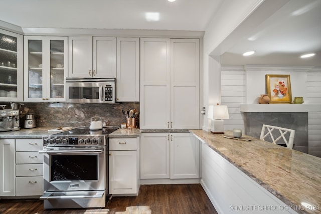 kitchen featuring decorative backsplash, appliances with stainless steel finishes, light stone countertops, white cabinets, and dark hardwood / wood-style flooring