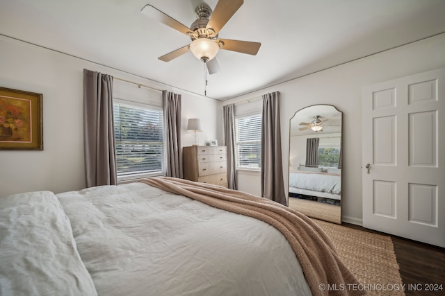 bedroom with multiple windows, ceiling fan, and dark hardwood / wood-style floors