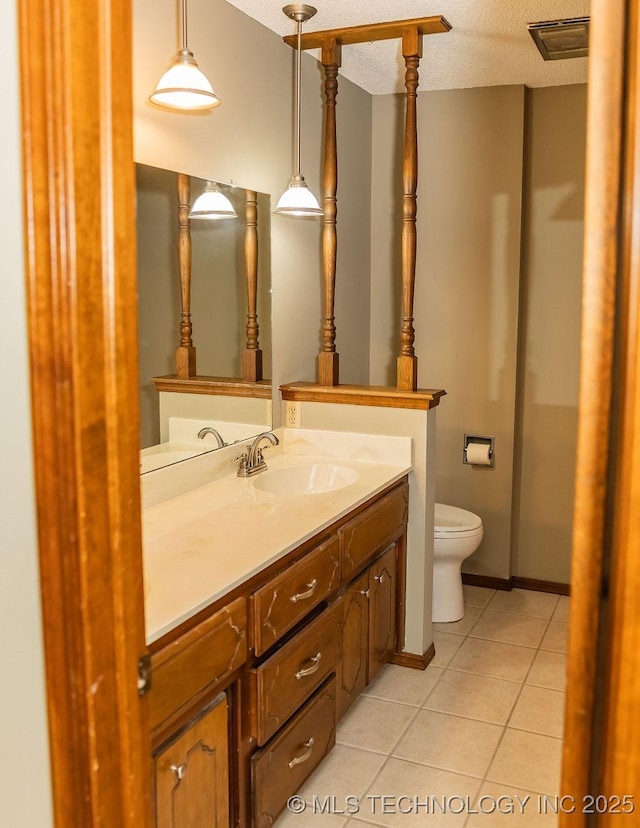 bathroom with tile patterned flooring, toilet, vanity, and a textured ceiling
