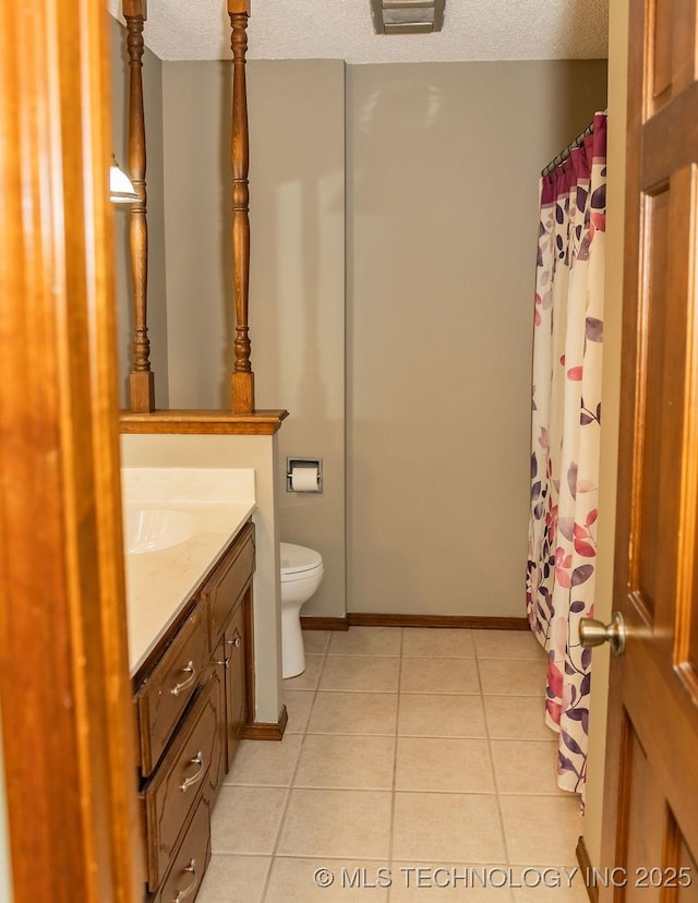 bathroom featuring vanity, toilet, tile patterned flooring, a textured ceiling, and baseboards