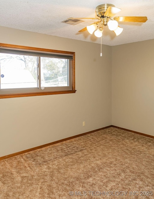 carpeted empty room with a ceiling fan and baseboards