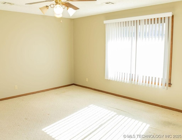 unfurnished room featuring ceiling fan, carpet, plenty of natural light, and baseboards
