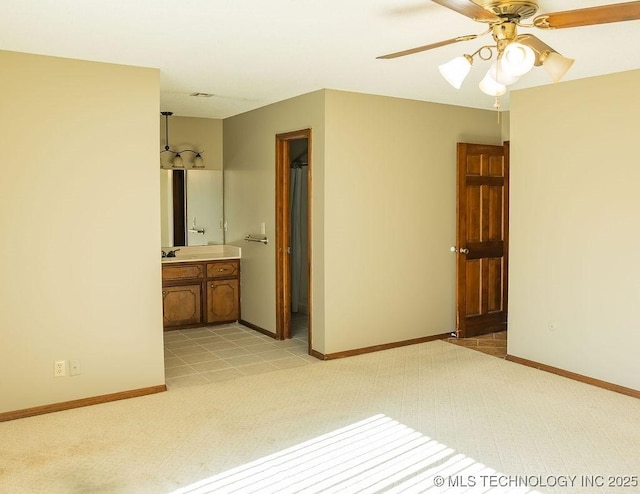 unfurnished room with ceiling fan, baseboards, light carpet, and a sink