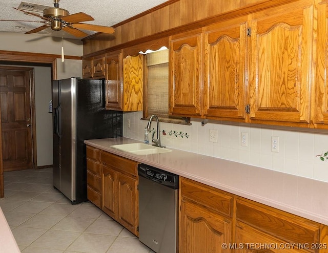 kitchen with appliances with stainless steel finishes, a sink, ceiling fan, tasteful backsplash, and light tile patterned floors
