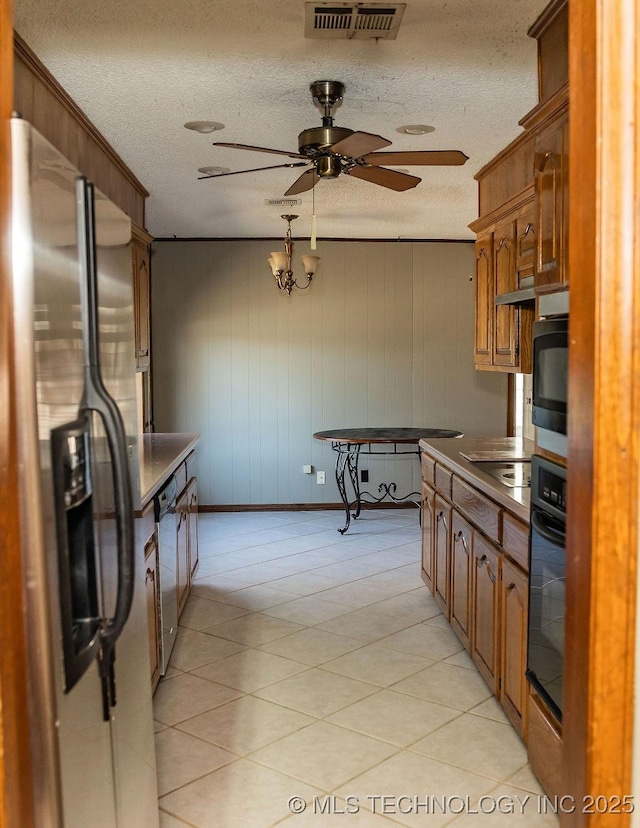 kitchen featuring black appliances, a ceiling fan, brown cabinetry, a textured ceiling, and baseboards