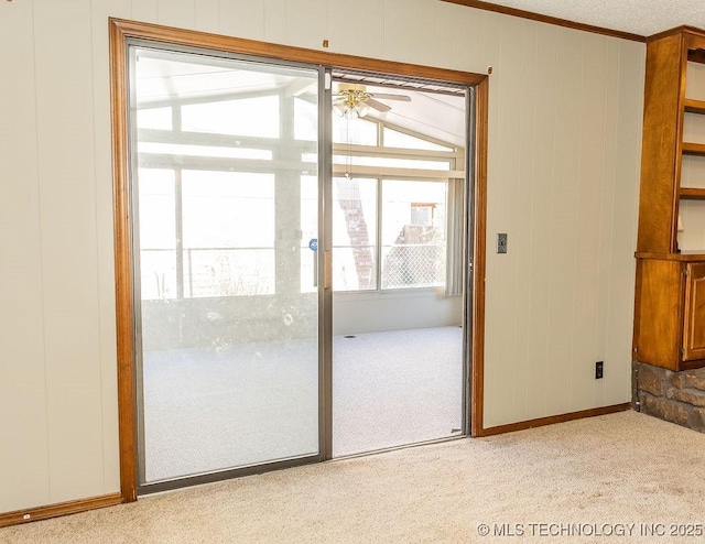 doorway to outside featuring carpet flooring, a ceiling fan, baseboards, and crown molding