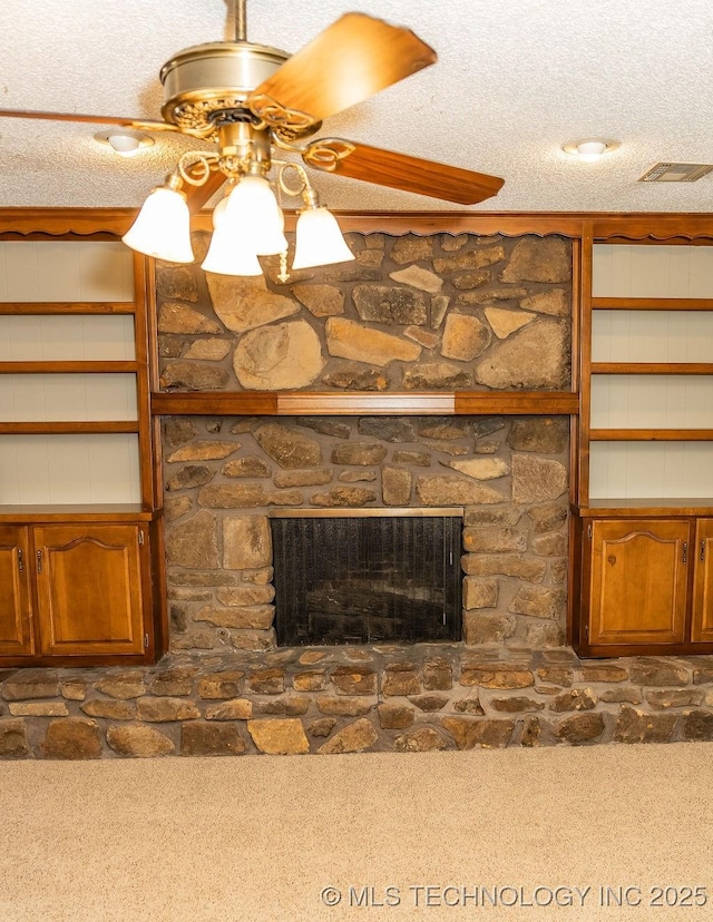 detailed view of carpet floors, a fireplace, a textured ceiling, and ceiling fan