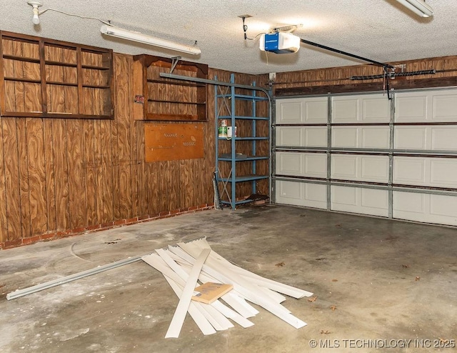 garage featuring a garage door opener and wood walls