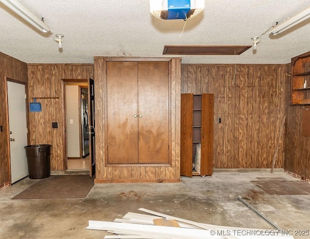 garage with wooden walls and a garage door opener