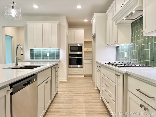 kitchen featuring light wood-type flooring, sink, backsplash, and stainless steel appliances