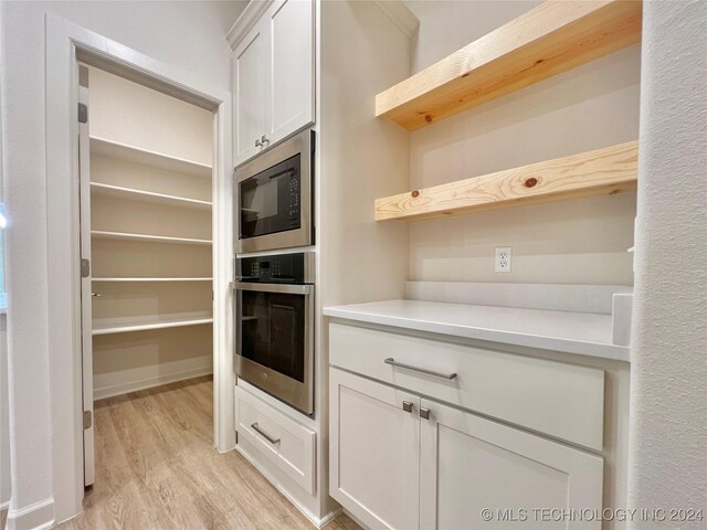 kitchen featuring light hardwood / wood-style floors, white cabinetry, and appliances with stainless steel finishes