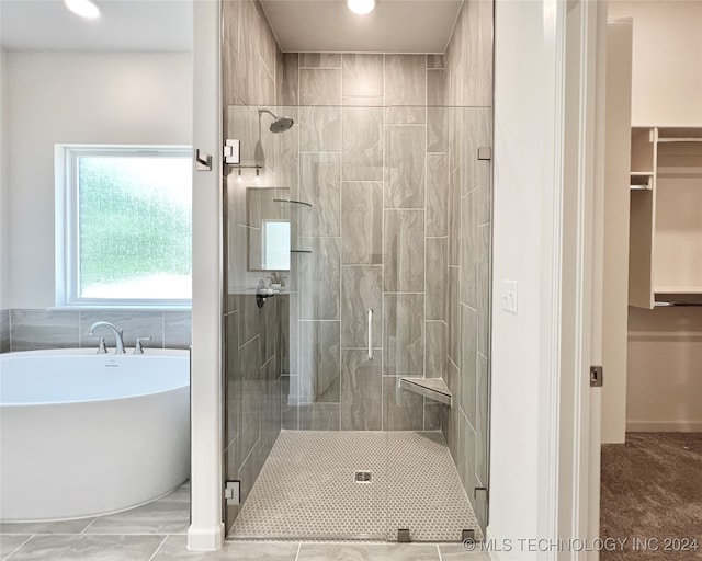 bathroom featuring shower with separate bathtub