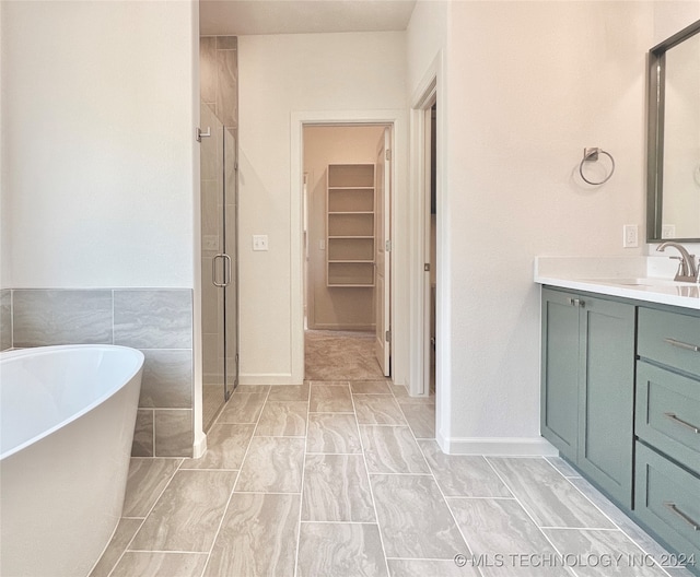 bathroom featuring tile walls, vanity, and shower with separate bathtub