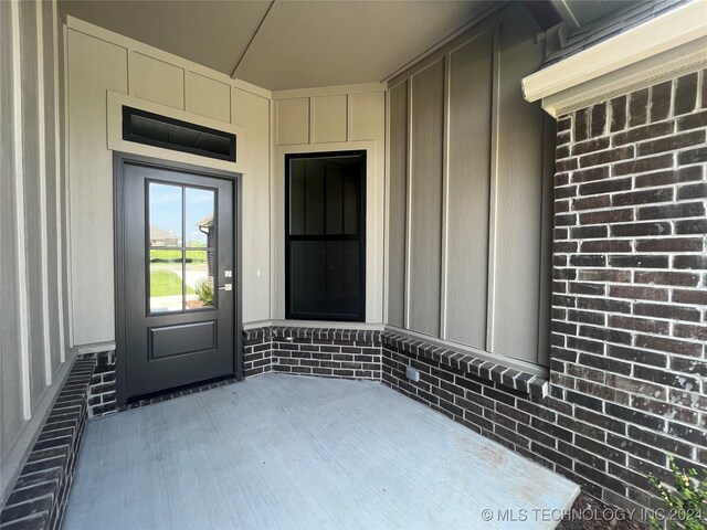 view of exterior entry featuring covered porch