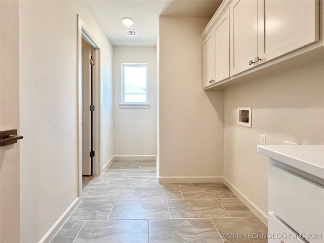 clothes washing area with cabinets and washer hookup