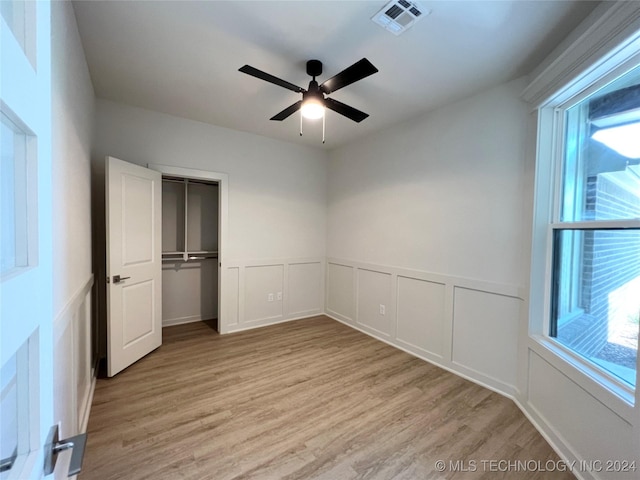 unfurnished bedroom featuring ceiling fan, light wood-type flooring, and a closet