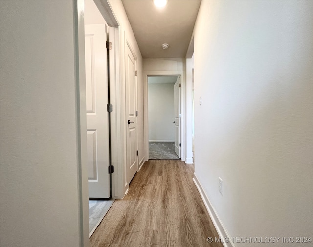 corridor with light wood-type flooring