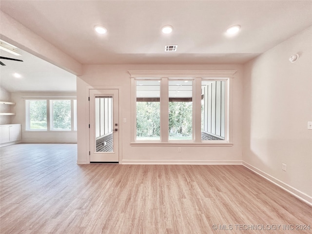 empty room with ceiling fan, a healthy amount of sunlight, and light hardwood / wood-style flooring