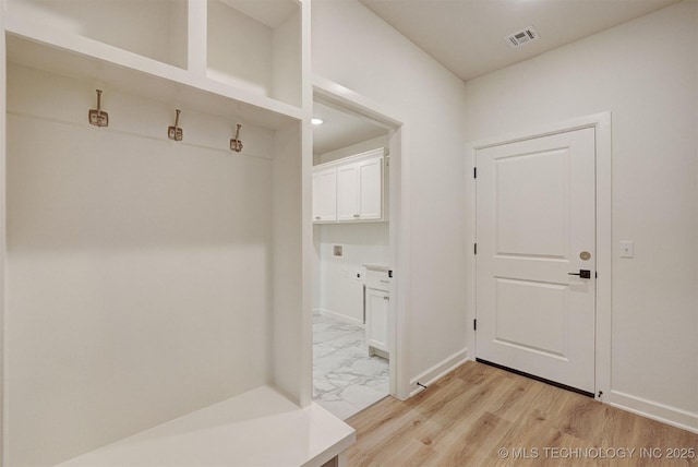 mudroom featuring light wood-style flooring, visible vents, and baseboards