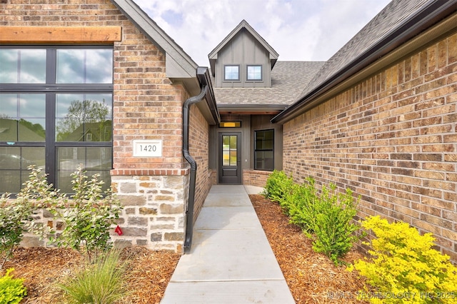 property entrance with brick siding, board and batten siding, and a shingled roof