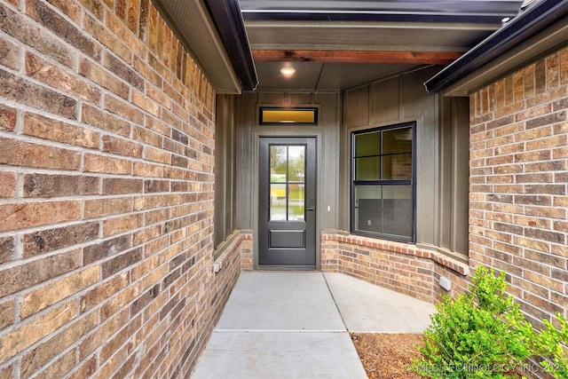 entrance to property featuring brick siding