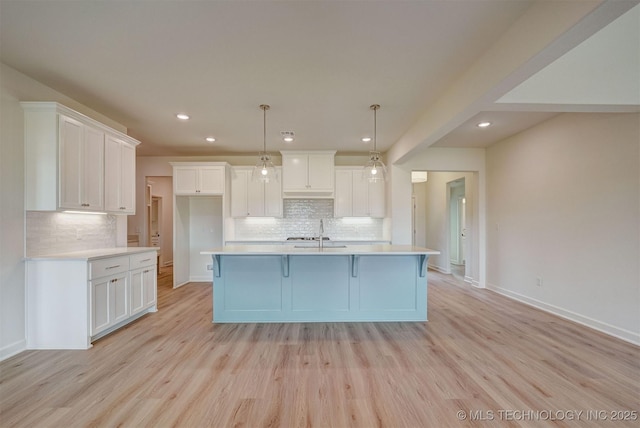 kitchen featuring white cabinets, light wood finished floors, and decorative backsplash