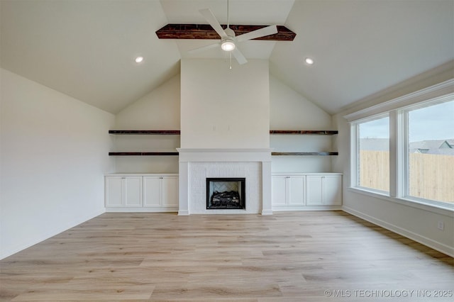 unfurnished living room with light wood-type flooring, recessed lighting, high vaulted ceiling, ceiling fan, and a fireplace