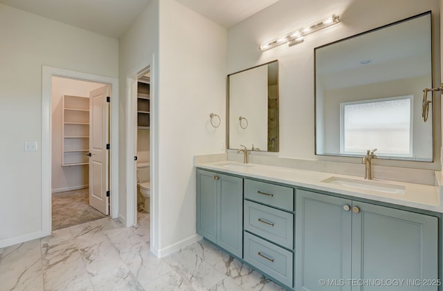 full bathroom with marble finish floor, baseboards, toilet, and a sink