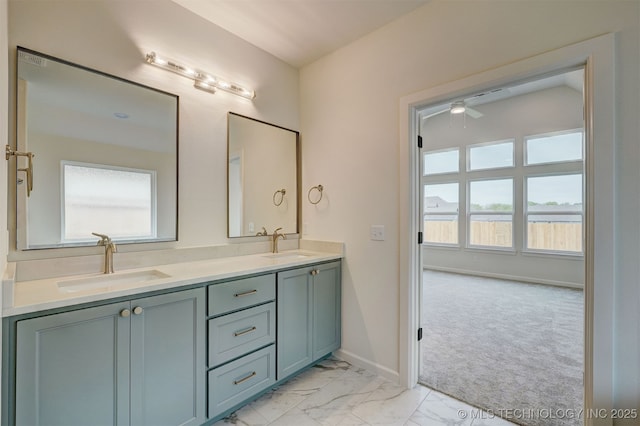 full bathroom featuring double vanity, marble finish floor, baseboards, and a sink