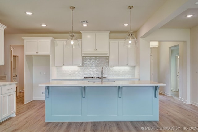 kitchen featuring a sink, visible vents, and light countertops