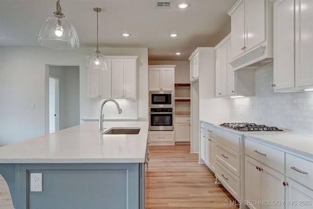 kitchen featuring white cabinets, visible vents, stainless steel appliances, and a sink
