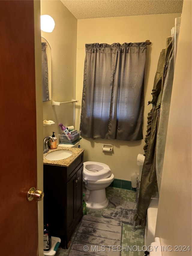 bathroom with vanity, a textured ceiling, and toilet