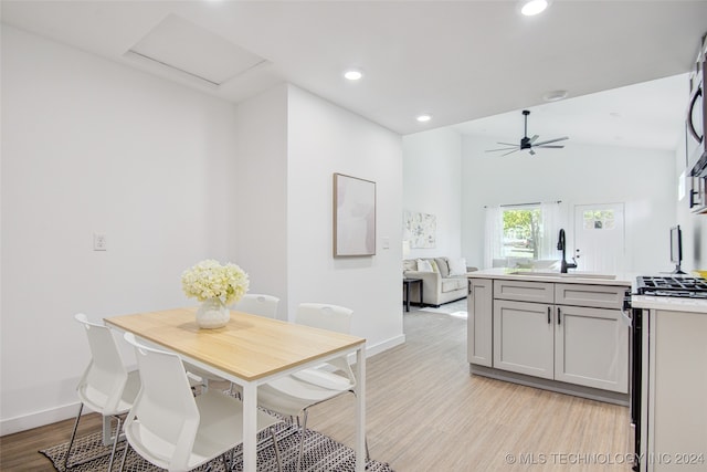 dining area with light hardwood / wood-style floors, ceiling fan, lofted ceiling, and sink