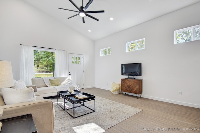 living room with light wood-type flooring, high vaulted ceiling, and ceiling fan