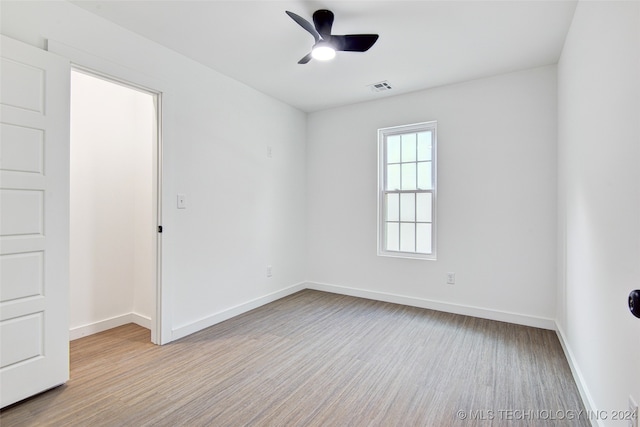 unfurnished room with ceiling fan and light wood-type flooring