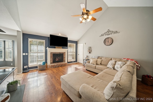 living room featuring hardwood / wood-style floors, ceiling fan, high vaulted ceiling, and a brick fireplace